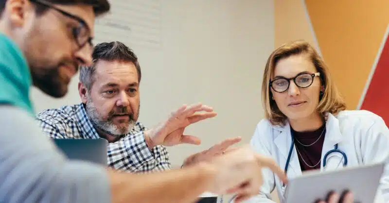 A senior clinical pharmacist discusses statistics on a tablet